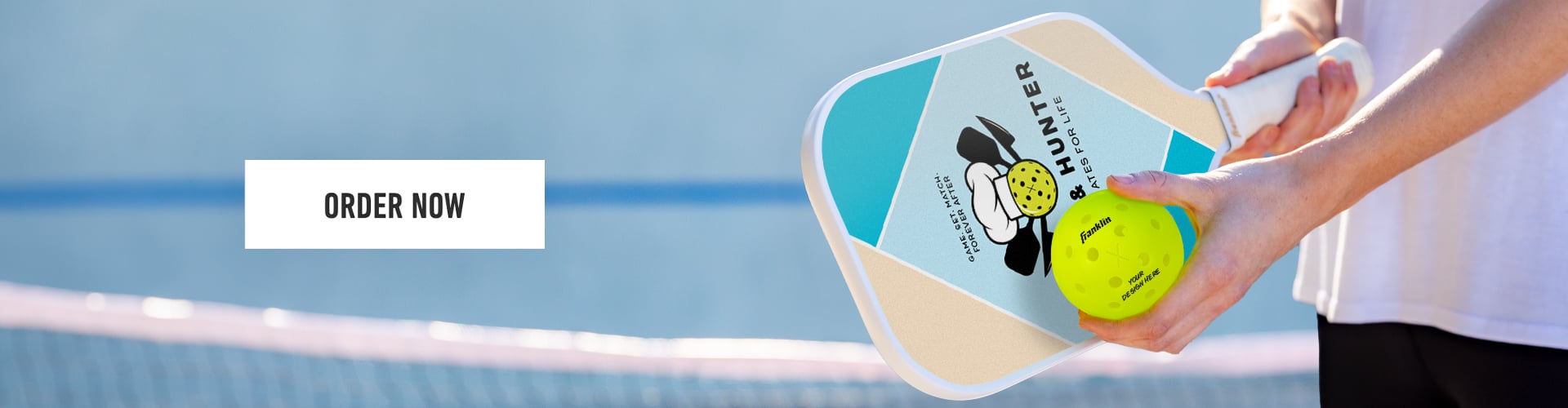pickleball player on a court holding a franklin custom pickleball paddle and pickleball