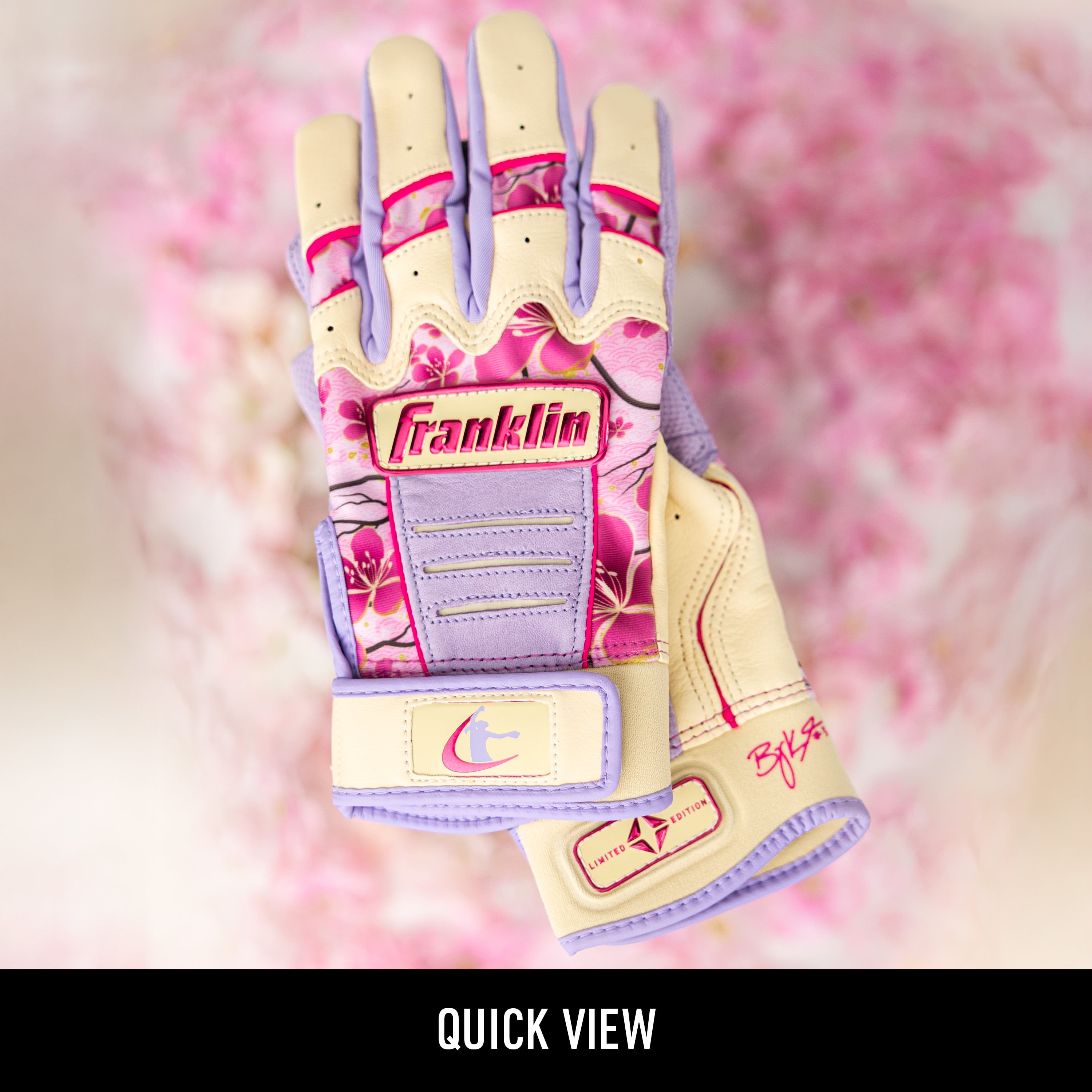 Franklin Baylee Klingler limited edition batting glove with a pink cherry blossom pattern and lavender accents displayed against a blurred pink floral background with a "Coming Soon" banner across the center