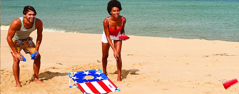 adults playing cornhole
